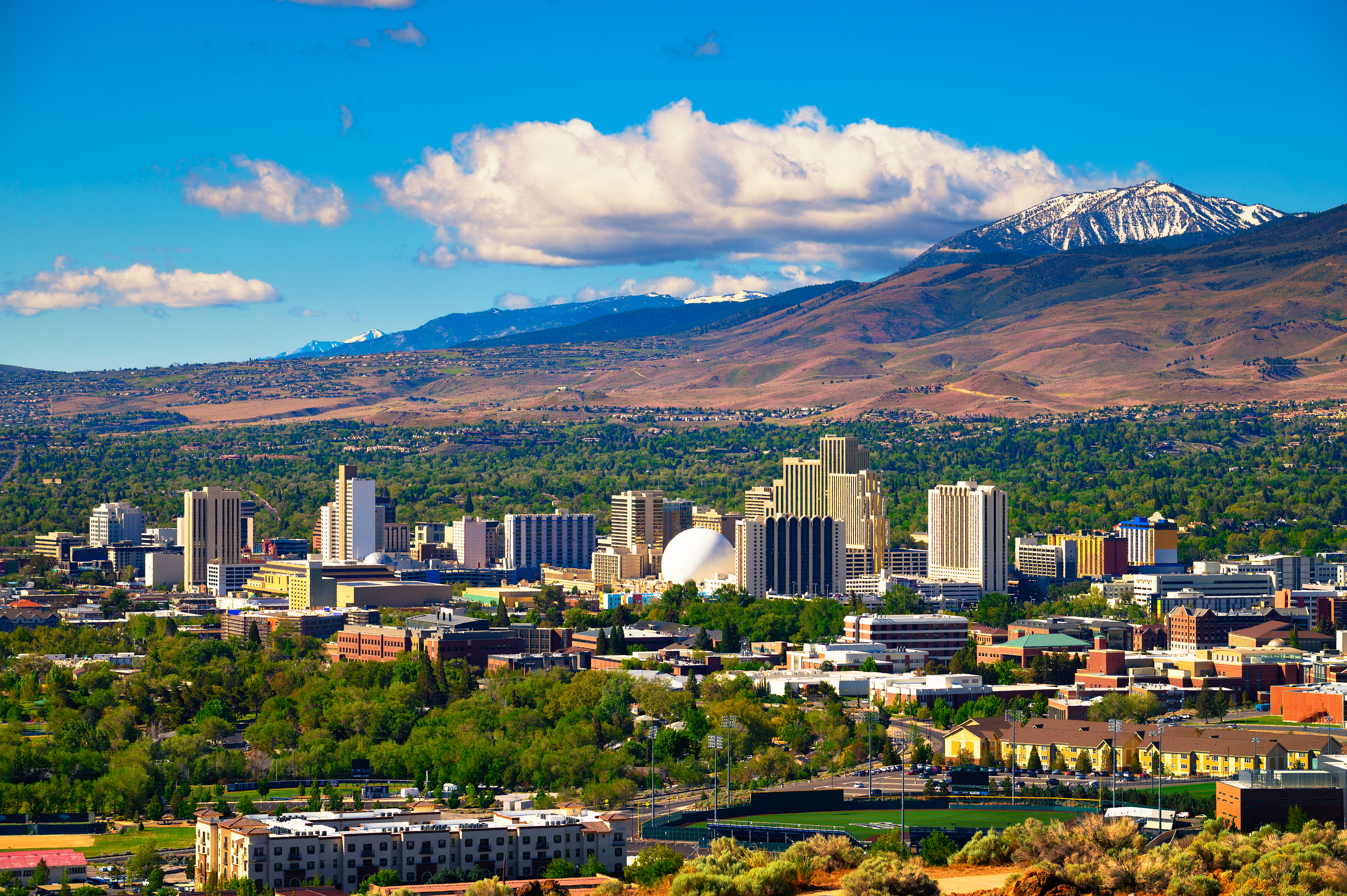 View of downtown Reno in the daylight, with mountains visible in the background